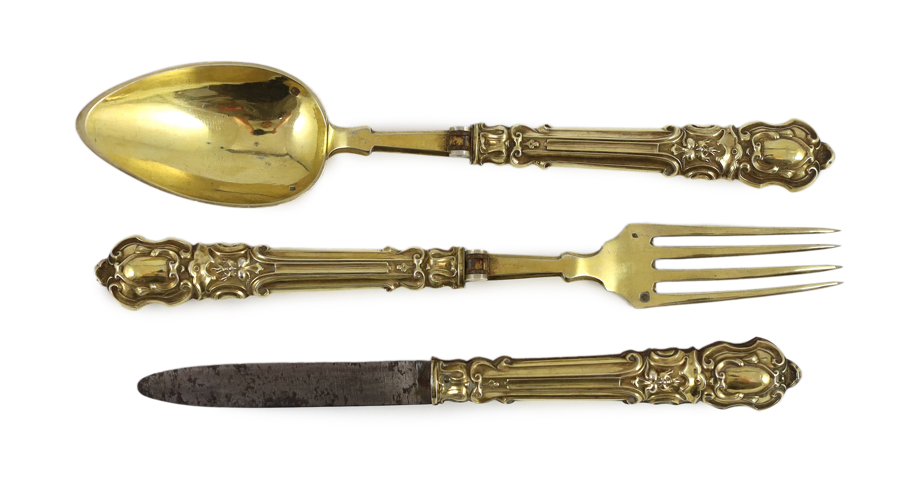 A 19th century French silver gilt three piece folding cutlery set with mascaroon green man decoration